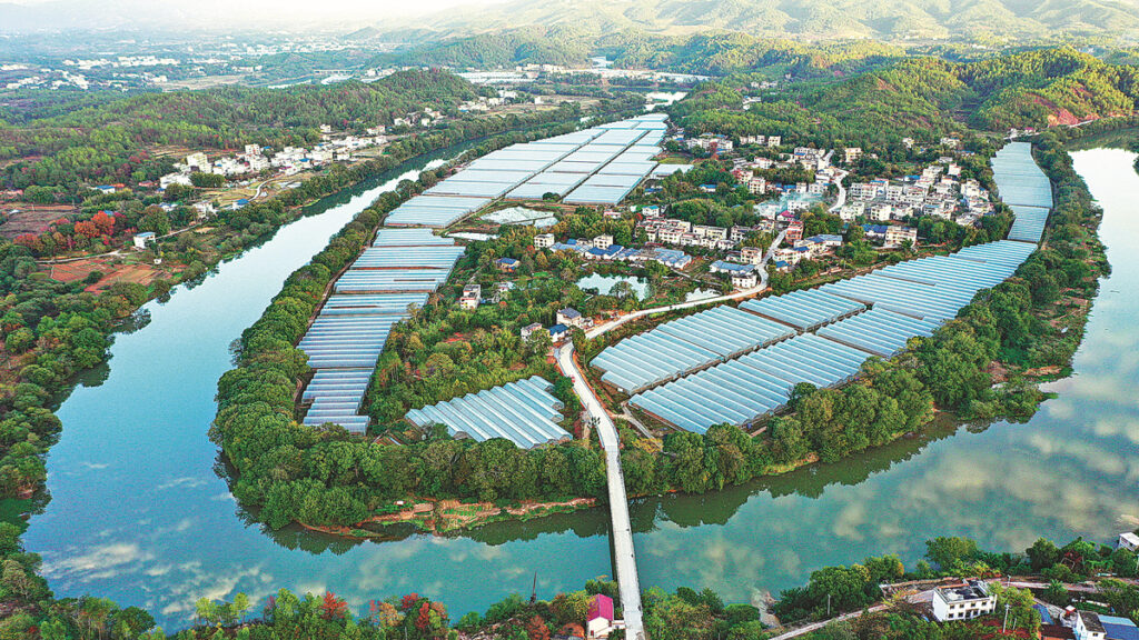 A river surrounds a village in Huichang county, Jiangxi province. [Photo by ZHU HAIPENG/FOR CHINA DAILY]